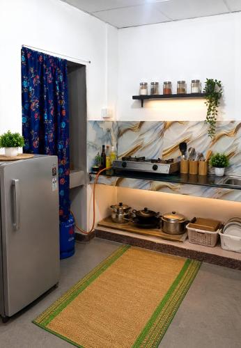 a kitchen with a refrigerator and some pots and pans at FS Hotel & villa in Arugam Bay