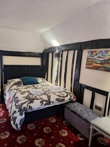 a bedroom with a bed and a bench in it at Cornerstone Budget in Ashford