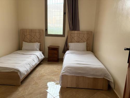 two beds in a bedroom with a window at Neoclassical apartment downtown in Casablanca