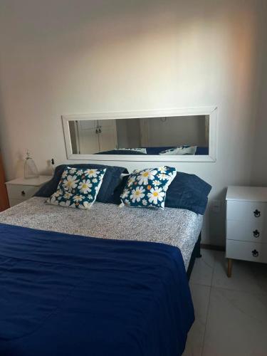 a bedroom with two beds with blue sheets and a mirror at Casa Nova Praia Vivamar in Cabo Frio