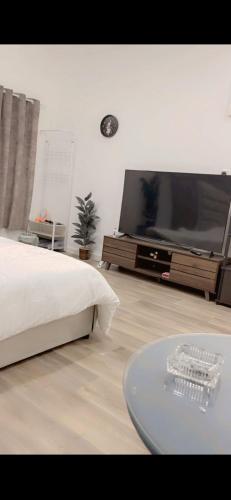 a living room with a large television and a table at Ksa2 in Hail