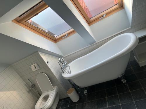 a bathroom with a sink and a tub and a toilet at Willa Oliwa in Gdańsk