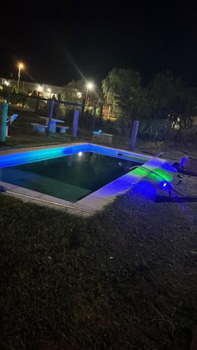 a swimming pool at night with blue and green lights at El triángulo finca familiar in Maco