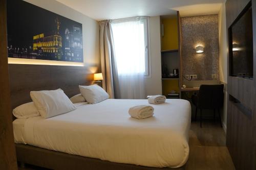 a hotel room with a bed with towels on it at Best Western Hotelio Montpellier Sud in Montpellier
