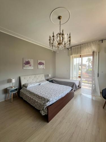 a bedroom with a bed and a chandelier at Bella Vita Guesthouse -parcheggio privato interno in Arona