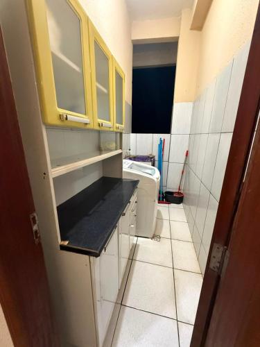 a small kitchen with yellow cabinets and a toilet at APT da Orla 305 in Santarém