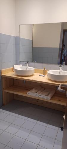 a bathroom with two sinks and a large mirror at Abries Hôtel in Abriès