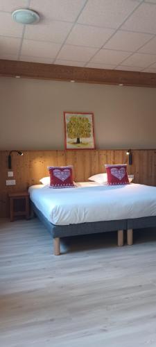 a bedroom with a large bed with red pillows at Abries Hôtel in Abriès