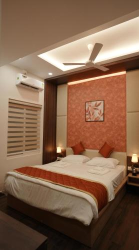 a bedroom with a large bed with a ceiling fan at Gamagashree Hotel and Fine Dine in Sāgar