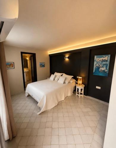 a bedroom with a large white bed in a room at Studio Appartement Perdicaris en rez de jardin - maison dhotes Dar Tanja in Tangier