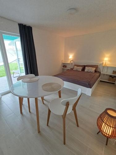 ein Schlafzimmer mit einem Bett, einem Tisch und Stühlen in der Unterkunft Чабарня in Pukhovka