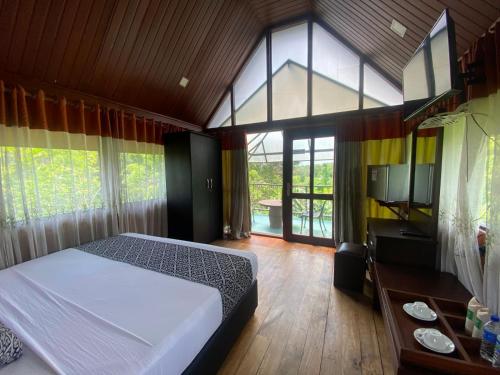 a bedroom with a bed and a large window at Nice Place Resort in Dambulla