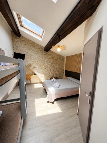 a bedroom with a bed in a room with a window at Hotel Saint Germain in Pézenas