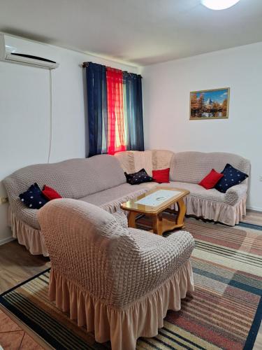 a living room with two couches and a table at Apartmani Medojević in Radanovići