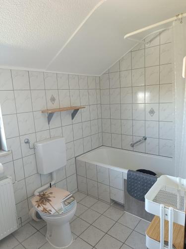 a bathroom with a toilet and a bath tub at FeWo Waschbär in Waldeck