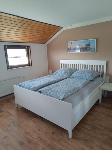 a bedroom with a white bed in a room at FeWo Waschbär in Waldeck