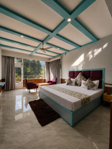 a bedroom with a large bed with a blue ceiling at Apple Flower Hotel - Personal Balcony, Lift, Garden and Mountain View in Manāli