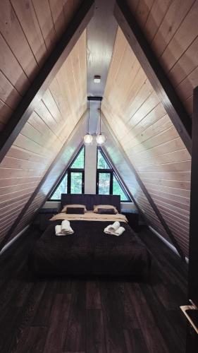 a attic bedroom with a bed with two towels on it at The Robian Chalet in Suceviţa