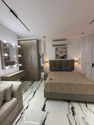 a bedroom with a large bed and a couch at Jasmine Studio Sharm El Sheikh in Dawwār Ruḩayyim