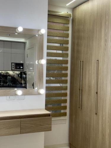 a kitchen with a wooden cabinet and a mirror at Jasmine Studio Sharm El Sheikh in Dawwār Ruḩayyim