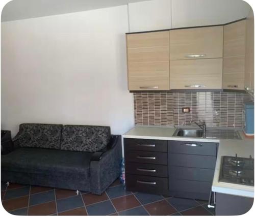 a living room with a couch and a kitchen at Adriatic Pearl Apartaments in Lezhë
