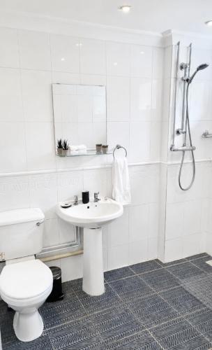 a white bathroom with a toilet and a sink at A quiet gem just outside Oundle in Oundle