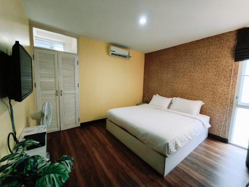 a bedroom with a bed and a flat screen tv at ๋Jongluxpakdee โรงแรมจงรักษ์พักดี in Uttaradit