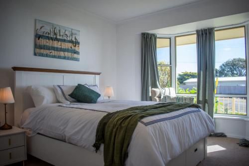 a bedroom with a large bed and a window at Beachfront Getaway Pet-Friendly & Near Boat Ramp - Koala Stay in Encounter Bay