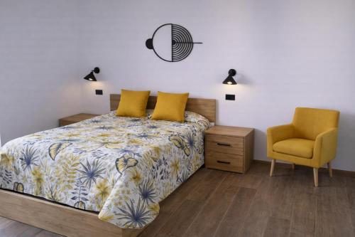 a bedroom with a bed and a yellow chair at Antana Guest House in Procida