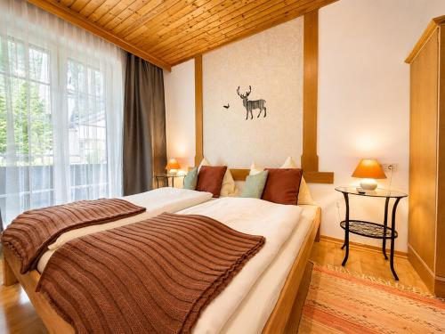 a bedroom with a large bed with a deer on the wall at ALPINA Appartements Mallnitz in Mallnitz