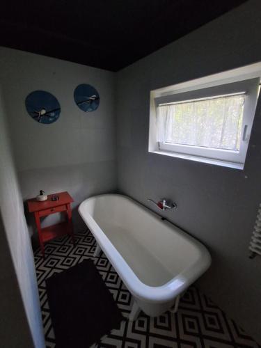 a white bath tub in a bathroom with a window at Hangvilla Vendégház in Miskolc