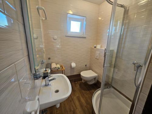 a bathroom with a shower and a sink and a toilet at Apartmani Marko in Nin