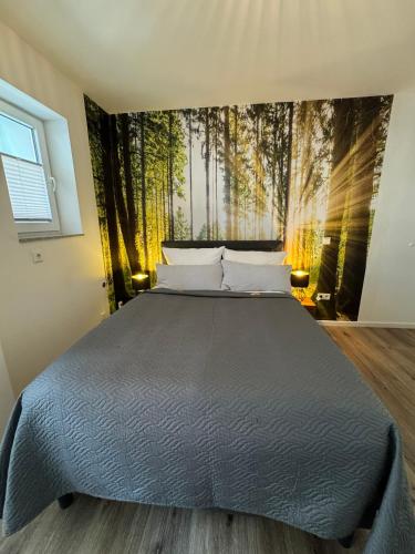 a bedroom with a bed with a forest mural on the wall at WOHNEN AM SCHLOSSPARK - Bad Salzuflen - nahe Messe, schnelles WLAN, freie Parkplätze, Frühstück verfügbar in Bad Salzuflen