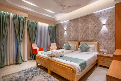 a bedroom with a bed and two orange chairs at Hotel Narenn HITEC CITY in Hyderabad