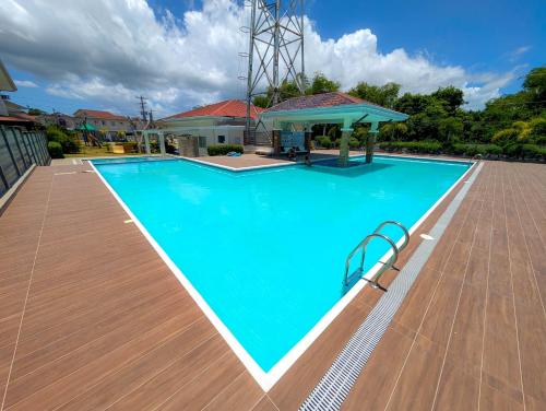 a large swimming pool with a wooden deck and a gazebo at Panglao 4 Bedroom Family and Group House With Pool in Dauis