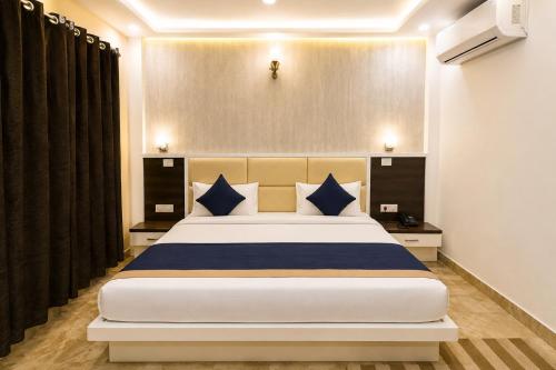 a bedroom with a large bed with blue pillows at Hotel Grand RK Residency Rukmani Vihaar - #PremManir #Chaar Dham #Parking #Affordable Stay in Vrindāvan