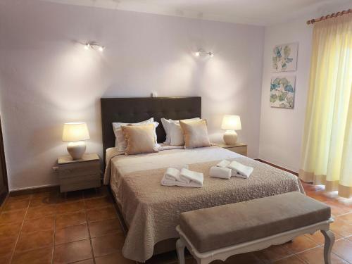 a bedroom with a bed with two towels on it at Aurora Sol in Luz