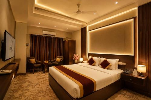 a hotel room with a large bed and a desk at Hotel Seva in Nagpur
