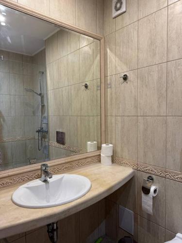 a bathroom with a sink and a large mirror at Видовые 2-комнатное апартаменты в комплексе Varna South Bay in Asparukhovo