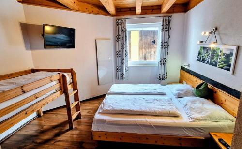 a bedroom with two bunk beds and a window at Schattaugut in Eben im Pongau