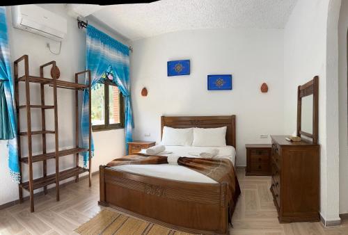 a bedroom with a bed in a room with blue curtains at Haven Hills Chaouen in Chefchaouen