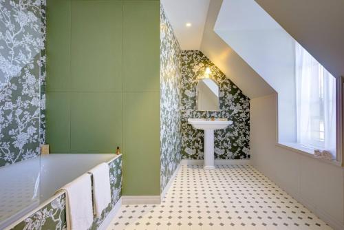 a bathroom with green walls and a sink at Villa Henriette in Cabourg