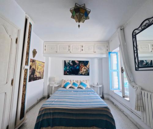 a bedroom with a bed with blue pillows at Artist's House in Dar Mimoun Bey