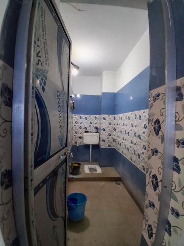 a bathroom with a toilet and a surfboard at Paras home in Deoghar