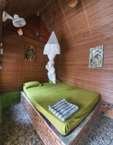 a room with a bed with a lamp on it at SumateraTrekingOrangutanPatrol in Bukit Lawang