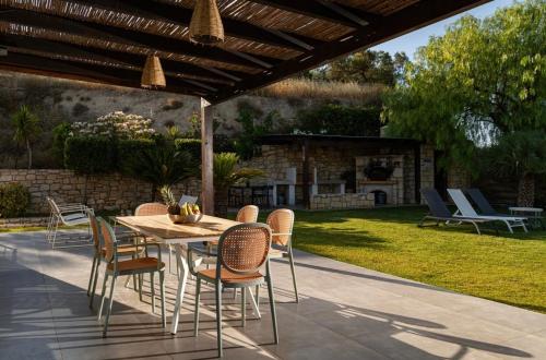 a patio with a table and chairs and a fireplace at Samiro Private Villa - Heated Pool & Hot tub in Áyios Míron