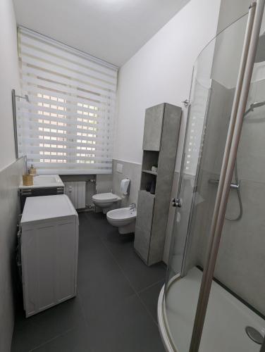 a bathroom with two toilets and a sink and a shower at Campesio Apartament in Piacenza