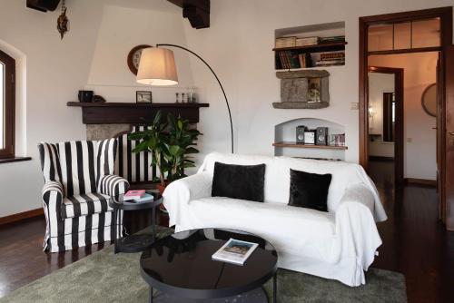 a living room with a white couch and a chair at Vista Menaggio Centro by LoveComo in Menaggio