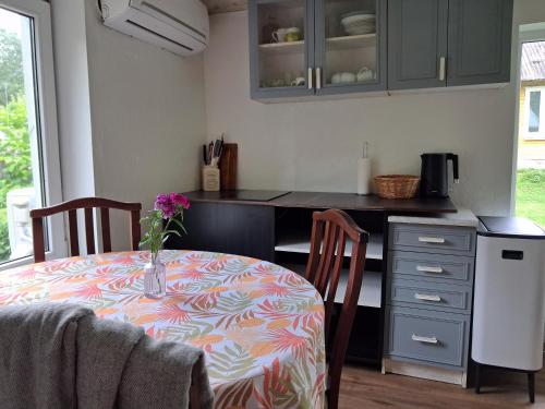 a kitchen with a table with a vase of flowers on it at Heinamaa Lodge with sauna in Lammasküla