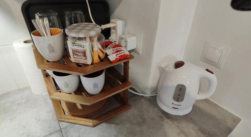 a shelf with cups and utensils and a coffee maker at El Rincón de la Magia in Soportújar